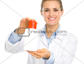 Smiling cosmetologist woman showing sun block creme