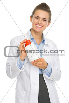 Smiling cosmetologist woman with sun screen creme