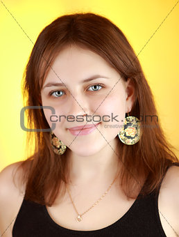 Vertical portrait of a girl 17 years of age on a yellow background
