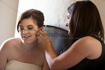 Woman Helping Bride with Earrings