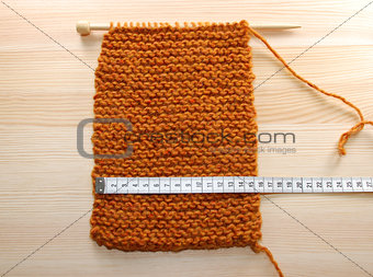 A length of knitting being measured in centimetres