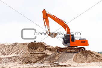 Excavator on sand pile
