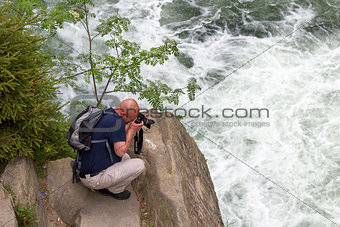man photographing a waterfall
