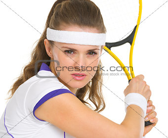 Portrait of confident female tennis player ready to hit ball