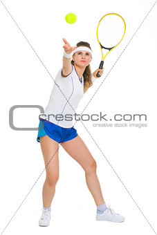 Full length portrait of female tennis player serving ball