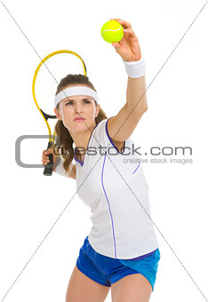 Confident female tennis player serving ball