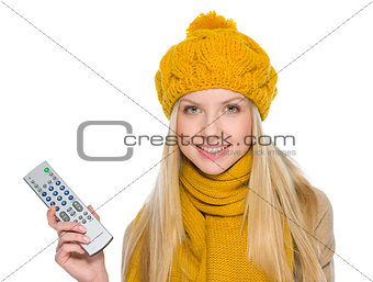 Happy girl in autumn clothes with tv remote control