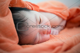 Newborn Asian baby girl on bed