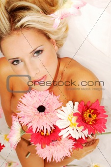 Beautyful young naked woman holding bunch of flowers