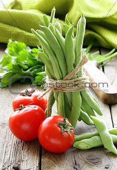 green peas  and tomatoes  on a wooden table, rustic style