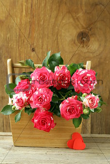 flowers roses in a vase on wooden background