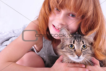 little girl hugging her cat