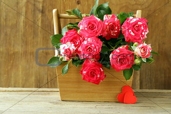 flowers roses in a vase on wooden background