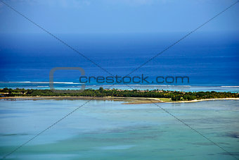 Small tropical desert island with turquoise waters and clear sky
