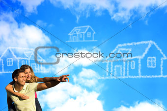 Happy coupleunder the blue sky dreaming of a house.