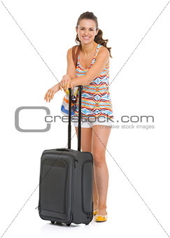 Full length portrait of happy young tourist woman with wheel bag