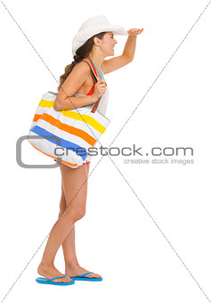 Full length portrait of beach young woman looking into distance