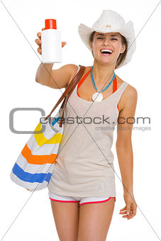 Happy beach young woman showing sun block creme