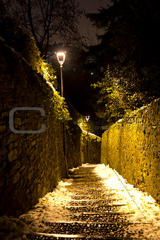 Old stone stairs with snow and lights at night