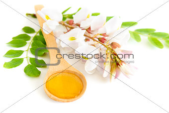 Honey in spoon with acacia flower