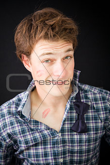 Young man with kiss trace on the cheek 