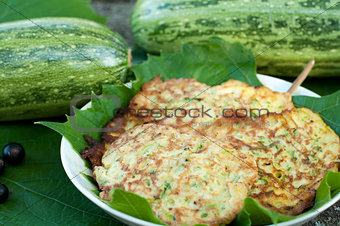 Pancakes with fresh zucchini on grape leaves