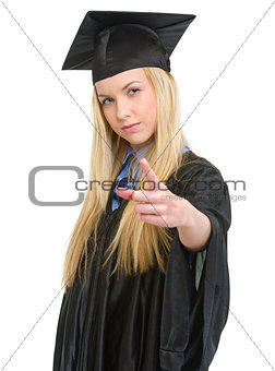 Concerned young woman in graduation gown threatening with finger
