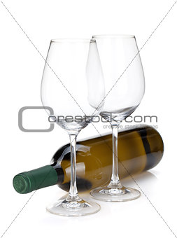 White wine bottle and two empty glasses