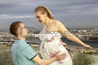 A young couple expecting a baby. A young pregnant woman walking