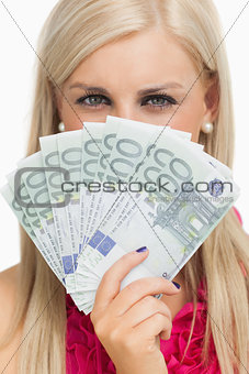 Green eyed woman holding 100 euros banknotes