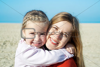 Autumn at the sea: happy mother and adorable little girl