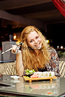 A young woman having lunch at a cafe laughing