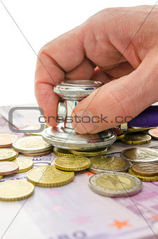 Detail of male hand checking money with stethoscope