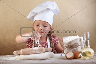 Little girl stretching the cookie dough