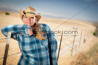 Beautiful Cowgirl Against Wire Fence in Field