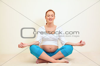 pregnant woman sitting in a lotus position