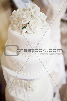 White layered wedding cake with roses on top
