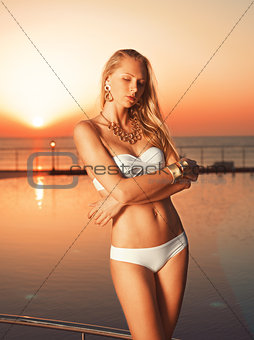 Girl near pool on the sunrise