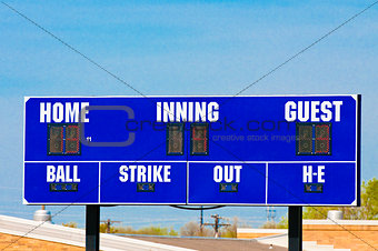 Baseball scoreboard with blue sky