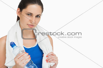 Brunette in sportswear with a towel and a bottle