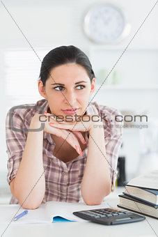 Woman looking away while leaning her chin on her hand