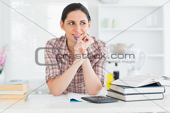 Woman looking away while holding a pen