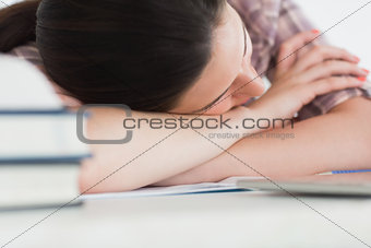 Woman leaning on the table next to books