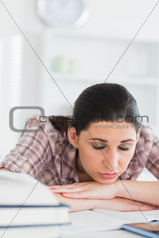 Woman with closed eyes leaning on a table