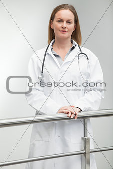 Female doctor standing against railing