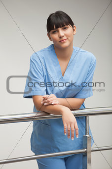 Content nurse leaning against railing
