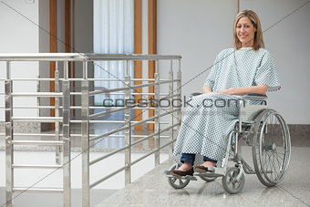 Smiling woman sitting in wheelchair in hospital corridor