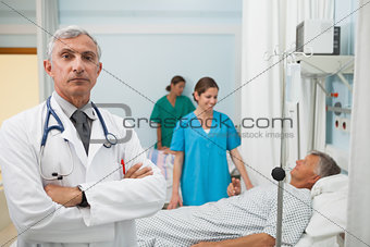 Doctor with folded arms in hospital room