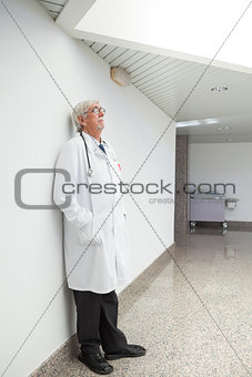 Doctor leaning against wall