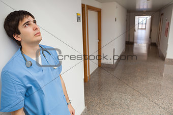 Distressed nurse leaning on wall